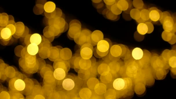 Abstrait flou d'or scintillant ampoules lumineuses sur fond noir .