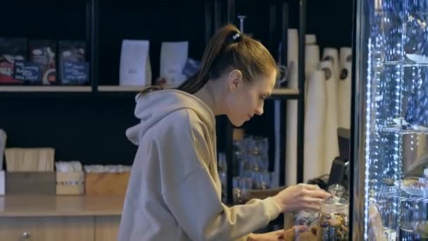 Mujer atractiva elegir un café galletas en la mesa escaparate en la cafetería . — Vídeos de Stock