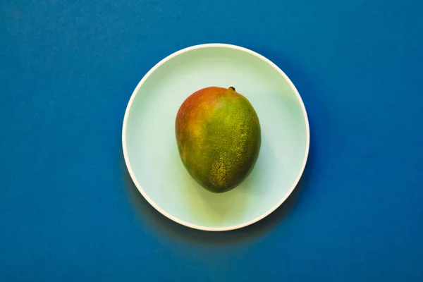 Mango acostado en una placa azul. Piso Lay . — Foto de Stock