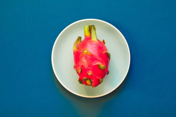 Pitaya. El primer plano de fruta de dragón madura en plato sobre fondo azul . — Foto de Stock