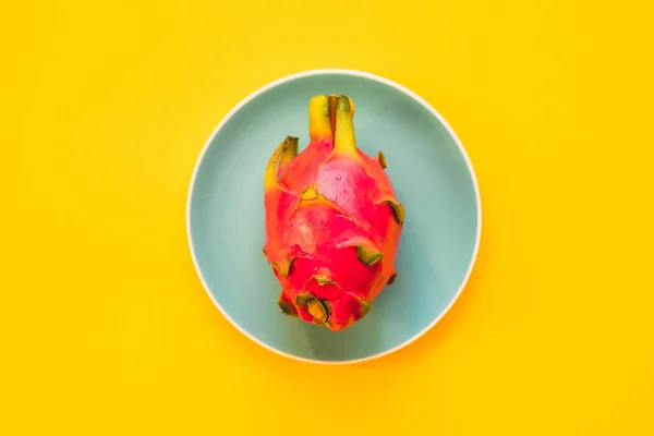 Pitaya. Le gros plan de fruits du dragon mûrs sur assiette sur fond jaune . — Photo