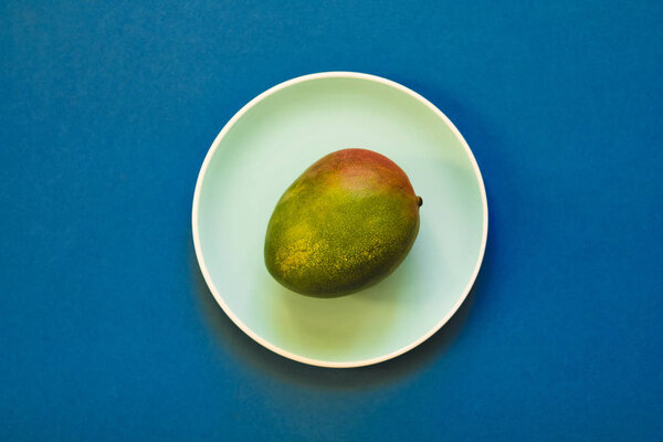 Mango Lying On A Blue Plate. Flat Lay.