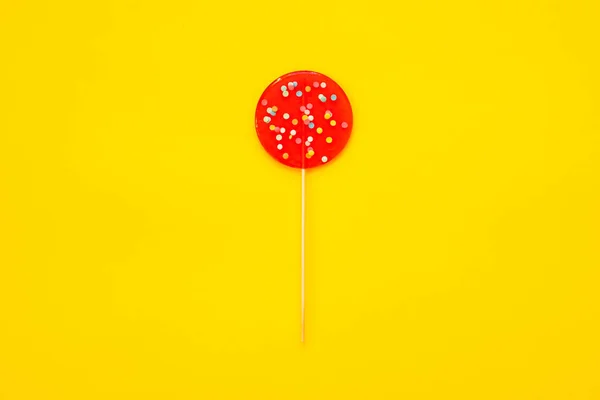 Een grote rode Lollipop, op een gele achtergrond. — Stockfoto