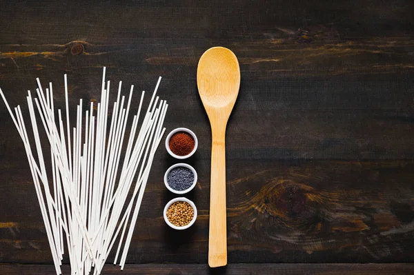 Different kind of spices and raw udon noodles on dark background. — 스톡 사진