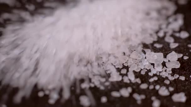 Crystals of white sea salt fall on the wooden table. — 비디오