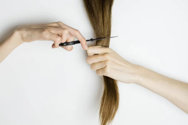 Mujer molesta corta su largo cabello liso con tijeras — Foto de Stock
