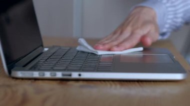 Yakın çekim sahnesi: kadın ıslak mendille dizüstü bilgisayarın klavyesini temizliyor. Novel Coronavirus ya da Corona Virüs Hastalığı (Covid-19). Antiseptik, Hijyen ve Sağlık Konsepti.