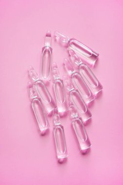 Pembe arka planda ilaç ampulleri. İlaç, tedavi..