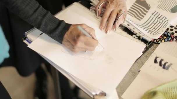 Дизайнер одежды, рисующая в своей книге идей — стоковое видео