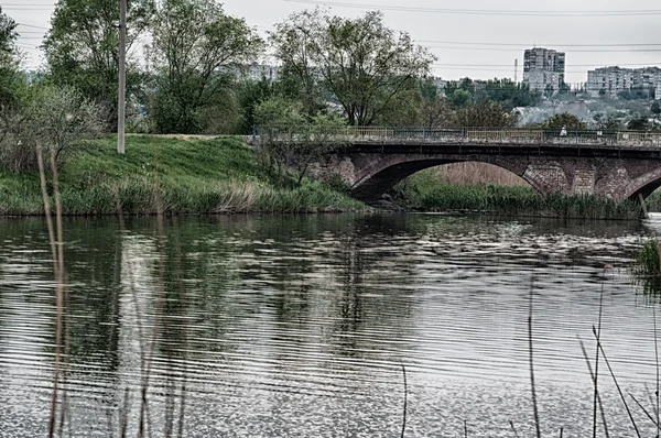 Nehir köprünün altından akar.