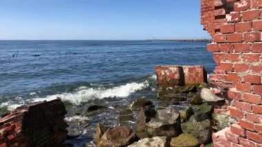  Deniz kenarındaki eski taşların üzerinde dalgalar kırılıyor.