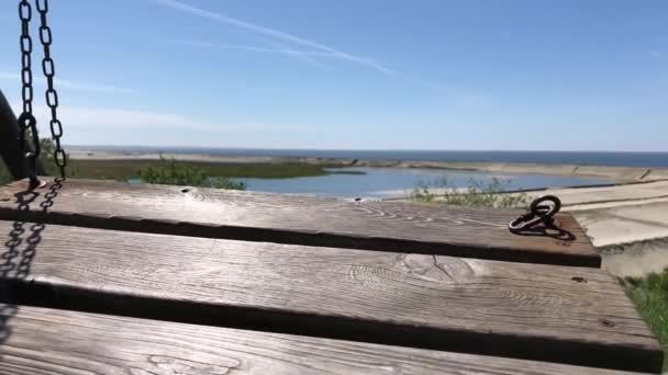 从海滩上的木制摇椅看海滨 — 图库视频影像