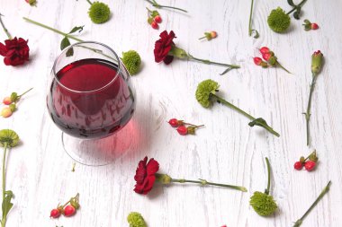 Masada kırmızı şarap bardağı var.