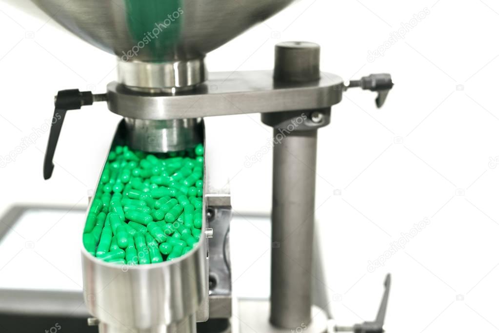 Tablets capsules sprinkled on slide in metal machine