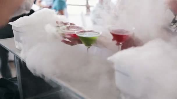 Glasses with multi-colored alcoholic drink in the smoke — Stock Video