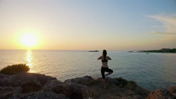 Menina meditando na praia ao pôr do sol — Vídeo de Stock