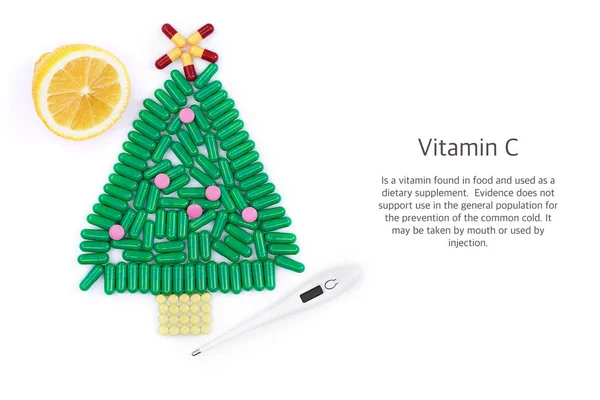 Tablets in form of Christmas tree thermometer and lemon underneath — Stock Photo, Image
