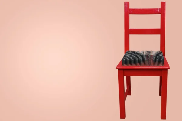 Red chair with spikes on the seat — Stock Photo, Image
