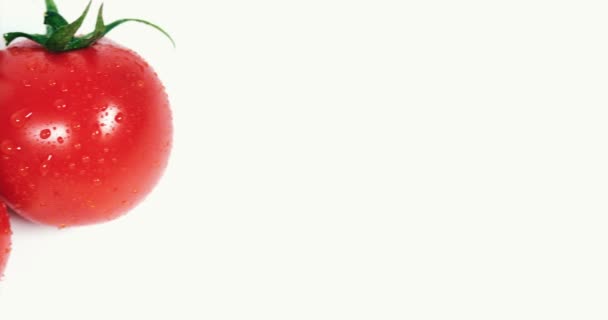Les tomates sont à côté du verre avec du jus de tomate — Video
