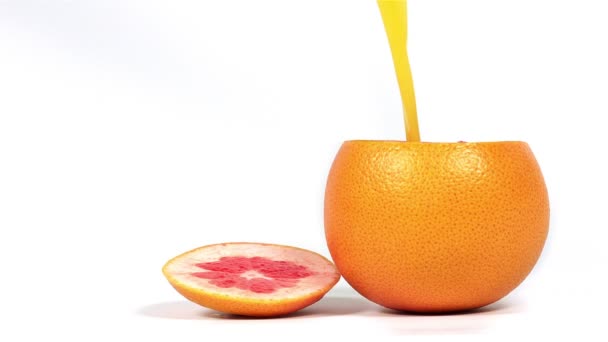 Vers geperst sap wordt gegoten in een grapefruit — Stockvideo