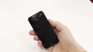 Bozuk telefon tutan bir adam.