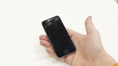 Bozuk telefon tutan bir adam.
