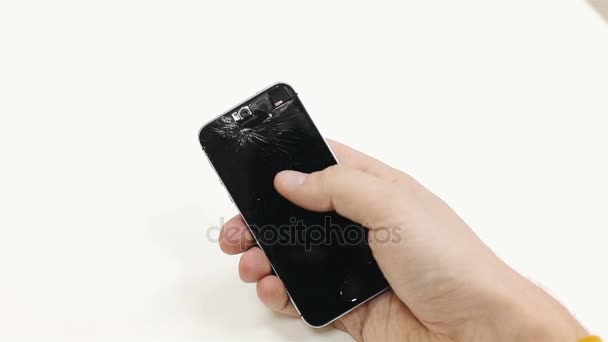 Un hombre sosteniendo un teléfono roto — Vídeos de Stock