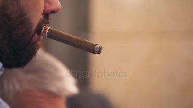 Bir sakallı bir adam bir puro içiyor