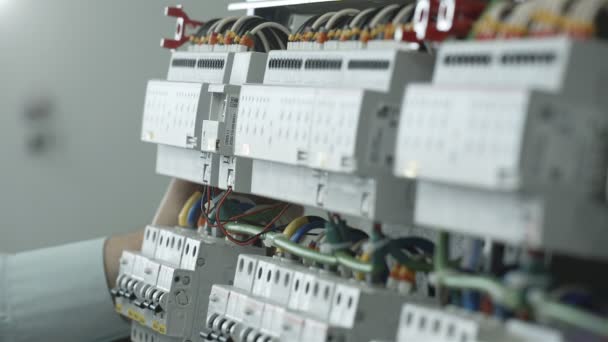 El empleado incluye un cable en el gabinete eléctrico — Vídeo de stock