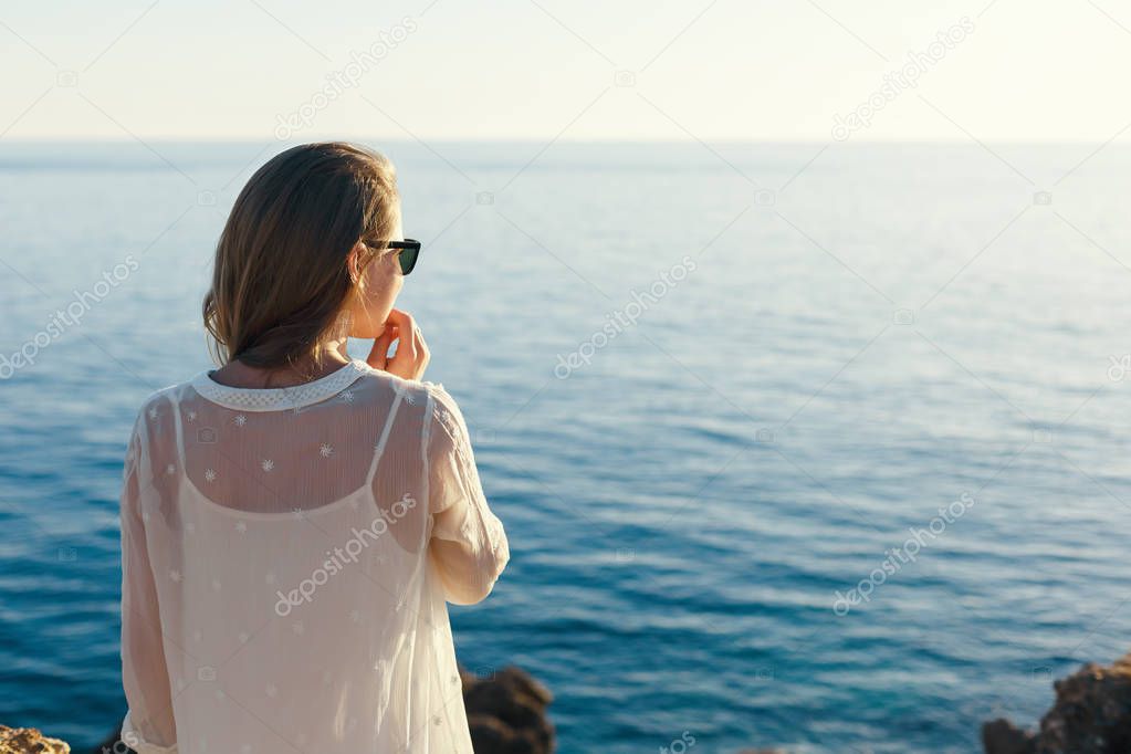 pensive girl looking at the sea sunset