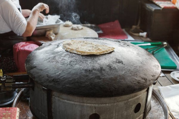 Granny chef cook Turkish pancake Gozleme on the stove
