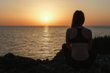 Gün batımında deniz tarafından meditasyon spor kız