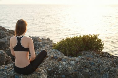 gün batımında sahilde meditasyon kız