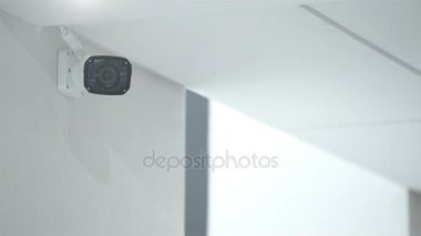 bir ofis binası beyaz duvara asılı güvenlik kamerası.