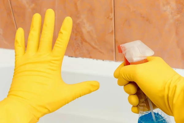 Gösteren dur kalıp banyo, bir sprey araç tutan diğer el içinde el.