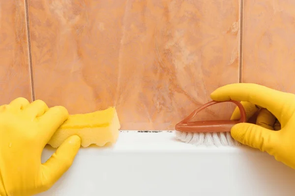 Hand in Hand mit Handschuhen will ich Schimmel im Badezimmer reinigen — Stockfoto