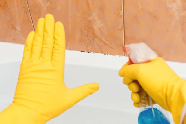 Ручной показ стоп-плесень в ванной комнате, другая рука с инструментом распыления . — стоковое фото