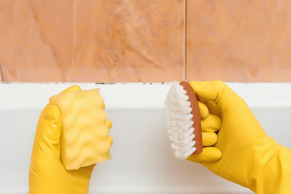 Hand in Hand mit Handschuhen will ich Schimmel im Badezimmer reinigen — Stockfoto