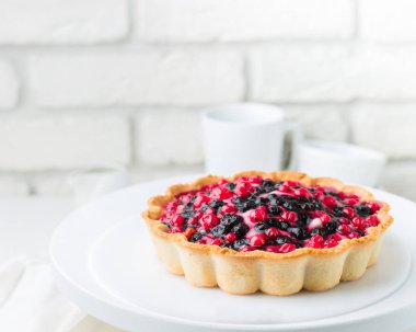 Ekşi krema ve çilek bir kafede. Kesilmiş bir parça ile modern bir pasta. Açık renkli, beyaz tuğla duvar, hafif yemekler ve kek standı. Kahve evinin atmosferini. 