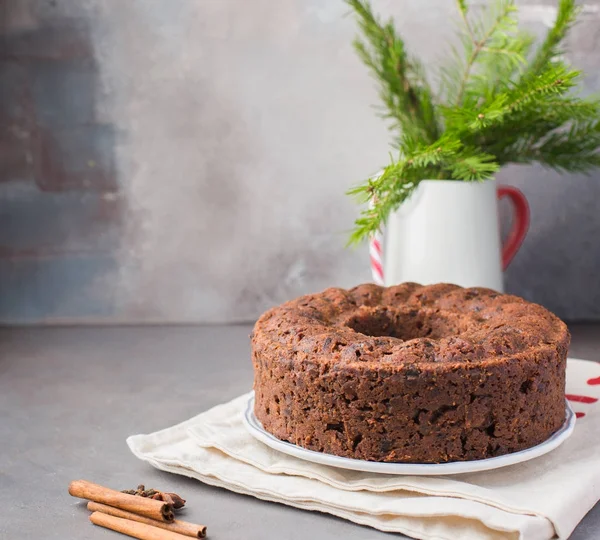 Geleneksel Noel İngilizce puding (meyveli kek) hafif beton bir arka plan üzerinde beyaz tabakta. Noel dekor tablo.  