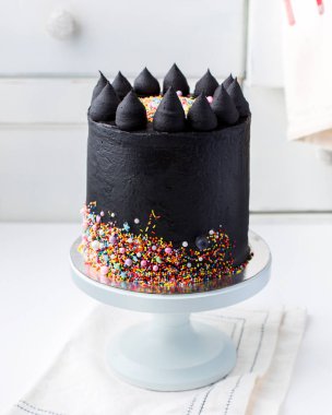 Güzel siyah çikolatalı pasta hafif bir antika arka plan üzerinde krem peynirli. Bir düğün pastası veya doğum günü pastası için orijinal fikir.