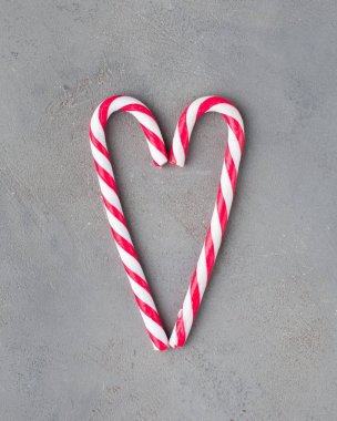 Gri beton zemin üzerine iki baston şekerler kalbinde. Güzel arka plan. Düz yatıyordu, en iyi görünümü