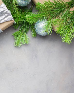 Noel arka planda gri-mavi renkler kraft kağıt sarılmış hediyeler, şeritler, cam Noel ağacı topları ve xmas ağacı ile. Düz yatıyordu, en iyi görünümü