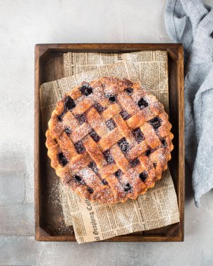 Amerikan vişneli tart, pudra şekeri gri beton zemin üzerine. Uzay kopyalayın. Metin için boş alan görüntüleyin. Metin için yer. Gıda fotoğraf. Düz yatıyordu, en iyi görünüm çok kolay mezarda. Zanaat gazete