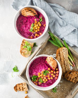 Pancar çorbası Hindistan cevizi sütü, pişmiş nohut, susam, gri beton zemin üzerine maydanoz ile krem. Pişmiş nohut baharatlar ile. Yararlı diyet çerez ve öğle yemeği. Metin için yer. Düz yatıyordu, en iyi görünümü