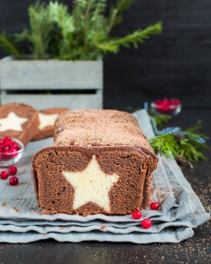 Bir çok çikolatalı kek ile koyu çikolata kaplı ve bir vanilya ile kakao serpilir içinde yıldız. Ahşap koyu arka plan üzerinde. Taze kızılcık, mükemmel serin Noel tatlısı ile dekore edilmiş