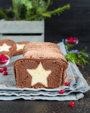 Bir çok çikolatalı kek ile koyu çikolata kaplı ve bir vanilya ile kakao serpilir içinde yıldız. Ahşap koyu arka plan üzerinde. Taze kızılcık, mükemmel serin Noel tatlısı ile dekore edilmiş