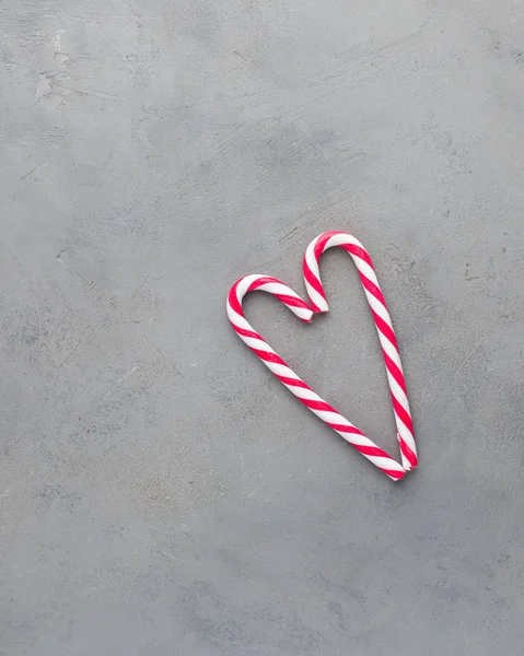 Heart of two candy canes on the gray concrete background. Beautiful background.Flat lay, top view