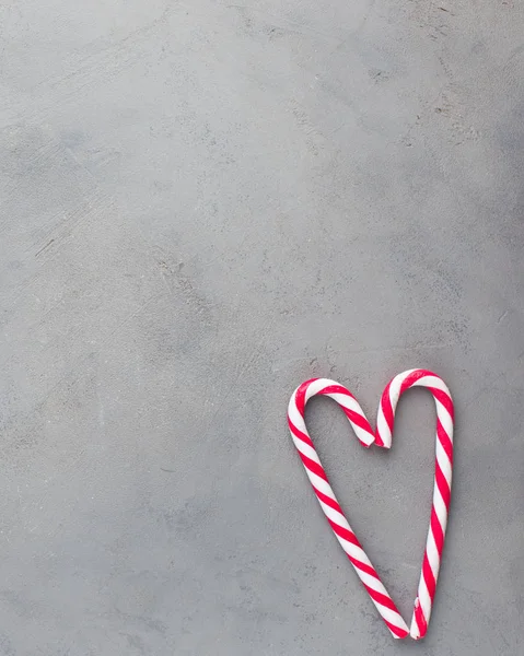 Heart of two candy canes on the gray concrete background. Beautiful background.Flat lay, top view