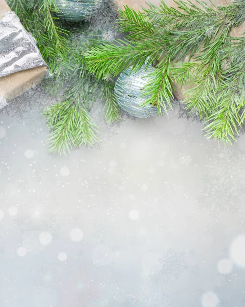 Noel arka planda gri-mavi renkler kraft kağıt sarılmış hediyeler, şeritler, cam Noel ağacı topları ve xmas ağacı ile. Düz yatıyordu, en iyi görünümü